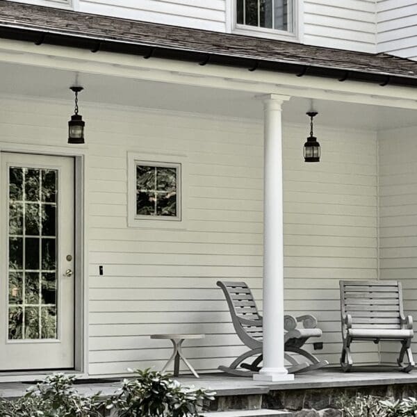 A porch with two chairs and a table.