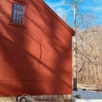 Red barn in winter landscape with shadows.