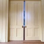 Cream sliding doors with scenic mural background.