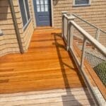 Wooden deck with metal railing and door.