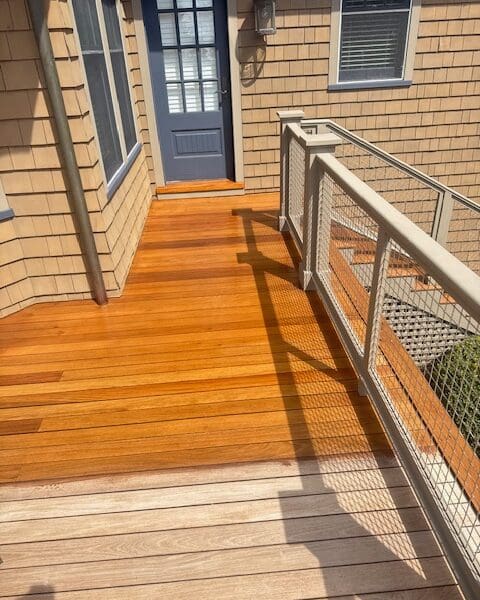 Wooden deck with metal railing and door.