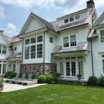 Large white house with manicured lawn.