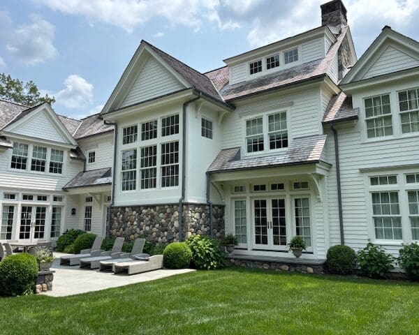 Large white house with manicured lawn.