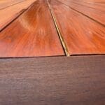 Wooden deck being stained with a brush.