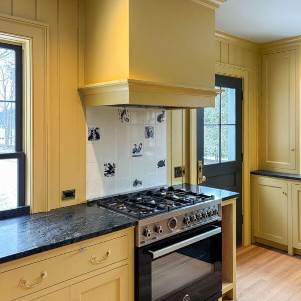 Yellow farmhouse kitchen with black range