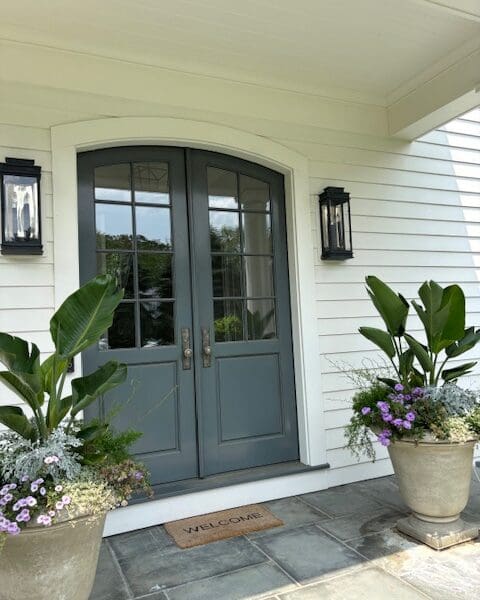 Blue double front doors with potted plants