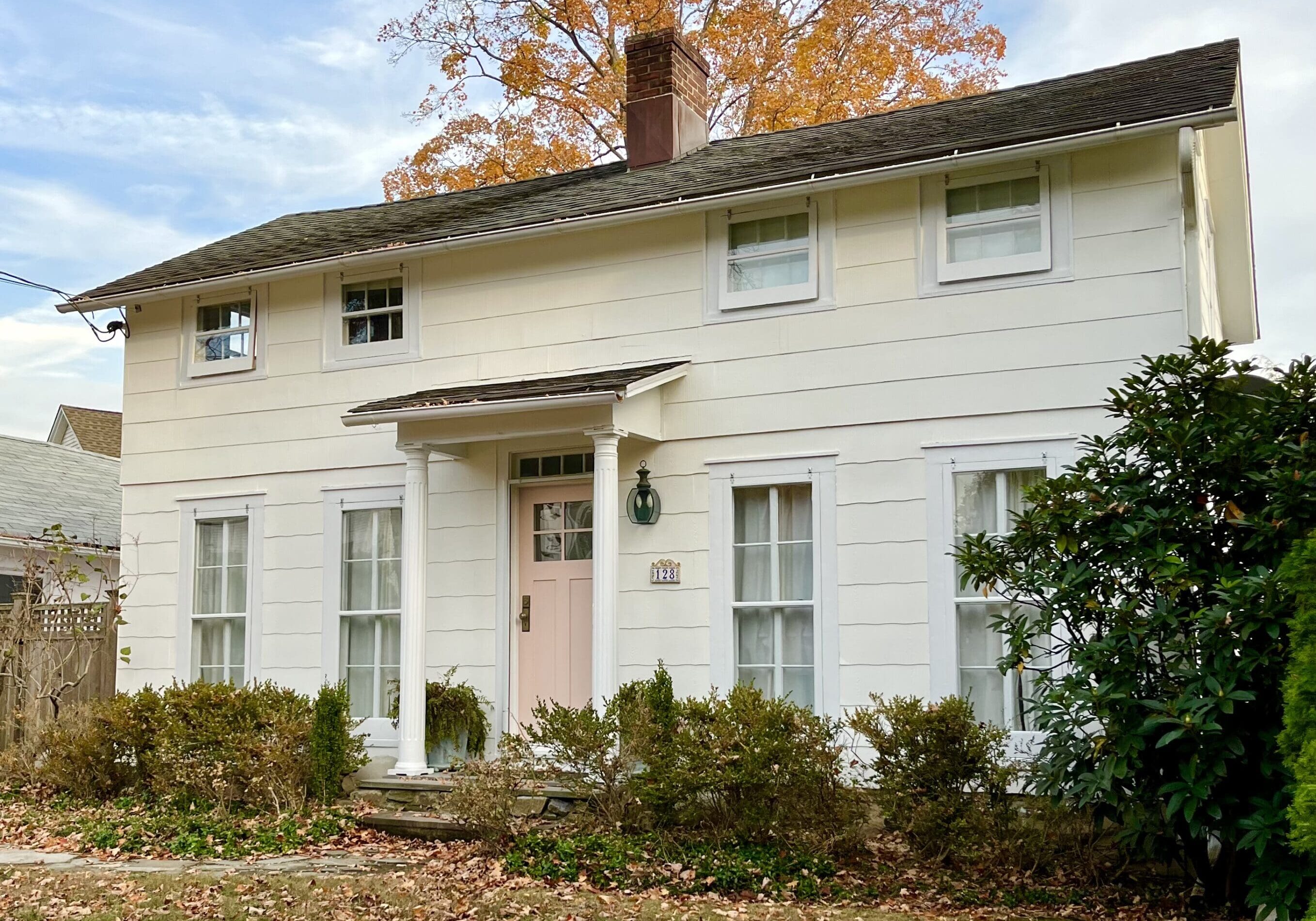 A white house with many windows and trees